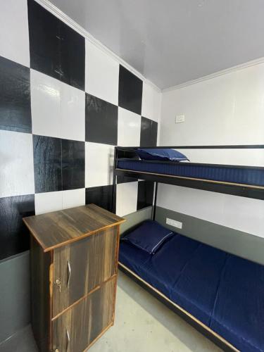 PedongにあるRilassare Stays Hostelの二段ベッド2台と木製キャビネットが備わる客室です。