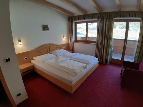 Un dormitorio con una cama grande y una ventana en Landgasthof Sonnegghof, en Castelvecchio