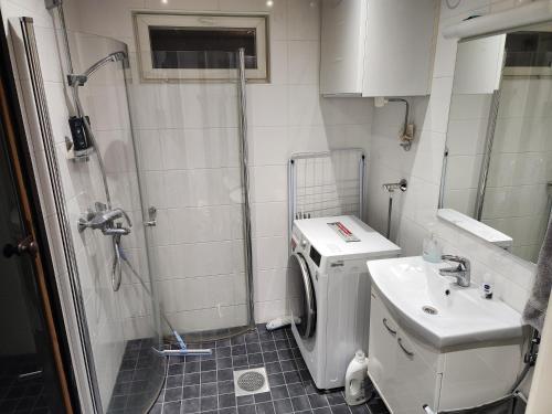 a small bathroom with a shower and a sink at Peuhuntie As 15 in Oulu