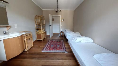 um quarto com duas camas e um lavatório em La Ferme du Colombier em Hamois