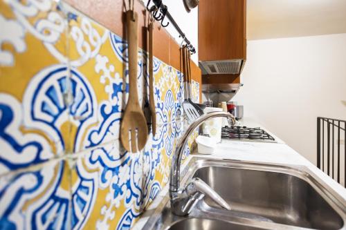 a kitchen with a sink and a stove at Ai Bottonai Casa 23 in Palermo