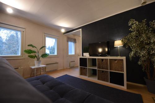 ein Wohnzimmer mit einem blauen Sofa und einem TV in der Unterkunft Perheystävällinen Paritalo Raisio in Raisio