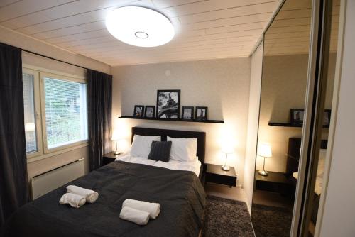 ein Schlafzimmer mit einem Bett mit zwei Handtüchern darauf in der Unterkunft Perheystävällinen Paritalo Raisio in Raisio