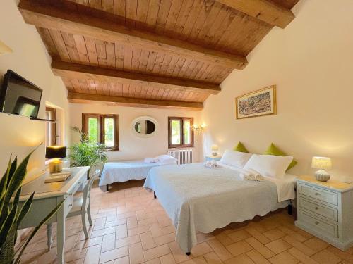 a bedroom with two beds and a desk in a room at Il Noceto in Monte San Giusto