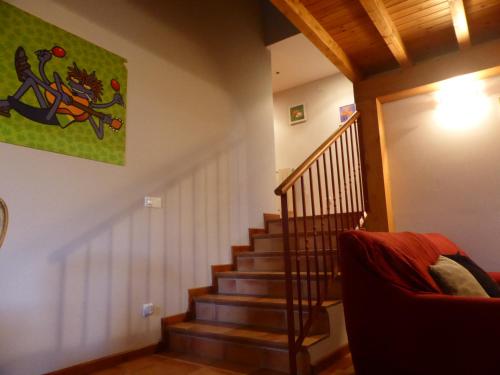a staircase in a living room with a red couch at Una casa con vistas en Pobes in Pobes