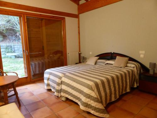 sypialnia z łóżkiem i dużym oknem w obiekcie Una casa con vistas en Pobes w mieście Pobes