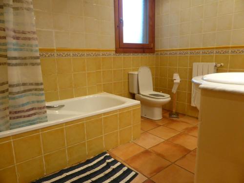 a bathroom with a tub and a toilet and a sink at Una casa con vistas en Pobes in Pobes