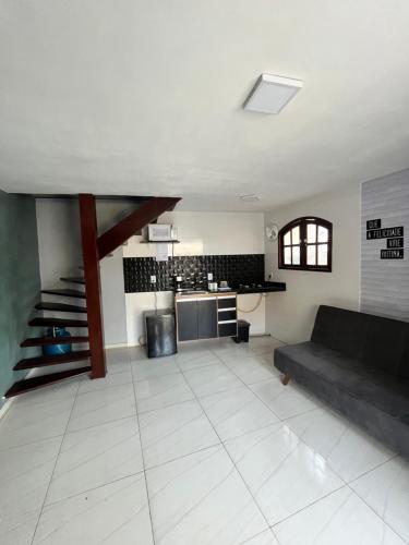 Una sala de estar con un sofá y una cocina. en Amós Beach House, en Arraial do Cabo