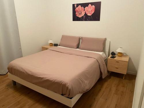 una camera con un letto con due comodini e due lampade di Mi'Ele Apartments a Pergine Valsugana