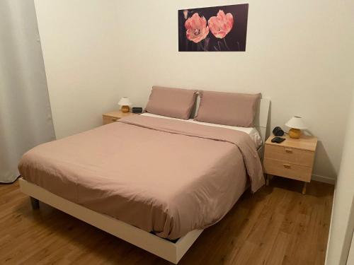 a bedroom with a bed with two night stands and two lamps at Mi'Ele Apartments in Pergine Valsugana