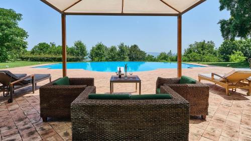 a patio with chairs and a table in front of a pool at Belvedere in Castel Viscardo