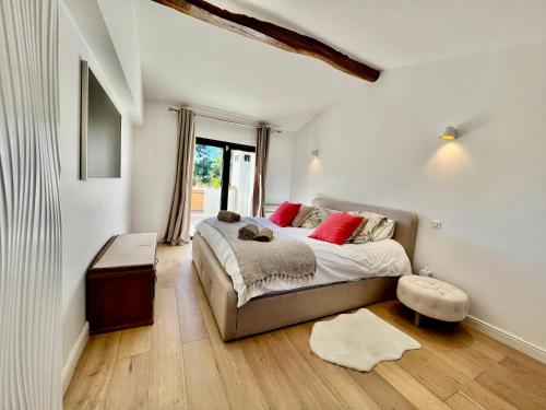 une chambre avec un lit avec des oreillers rouges dans l'établissement Villa MasDeline, à Mougins