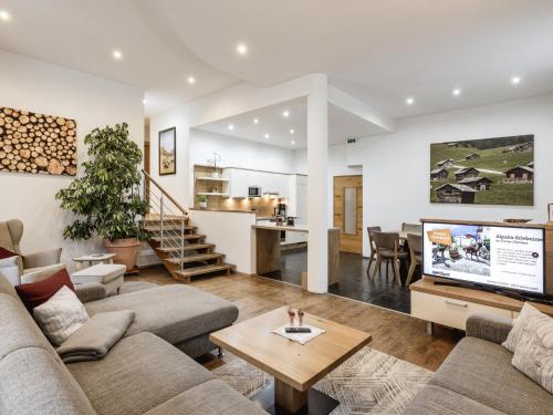 ein Wohnzimmer mit einem Sofa und einem TV in der Unterkunft Alpenapartments in Ried im Oberinntal