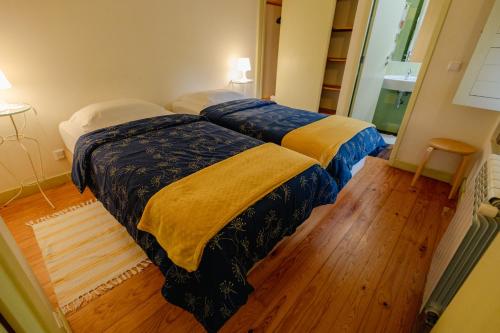 two beds in a room with wooden floors at Quinta da Cerdeira in Seia