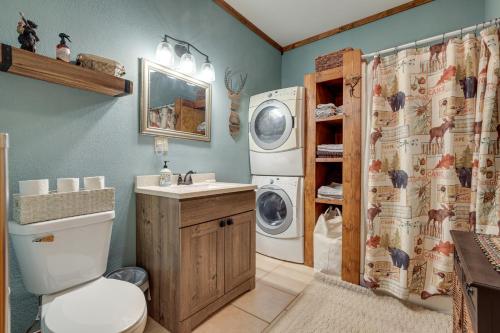 a bathroom with a toilet and a washer and dryer at 40-Acre, Off-Grid Wakefield Retreat with Gas Grill! in Wakefield