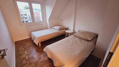 2 camas en una habitación pequeña con ventana en Luxus Penthouse Nähe Frankfurt, en Bad Homburg vor der Höhe