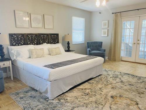 - une chambre avec un grand lit et une chaise bleue dans l'établissement 4 Bedrooms/Arcade/Heated Pool and Beach, à Palm Harbor