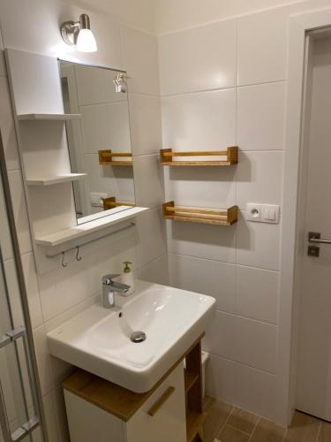 a white bathroom with a sink and a mirror at APARTMÁNY BIELA PÚŤ - Chopok SKI - Jasná in Demanovska Dolina