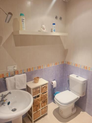 a bathroom with a white toilet and a sink at Casa Rural La Botica in Jarandilla de la Vera