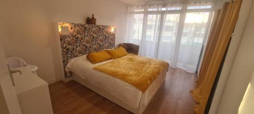 een slaapkamer met een bed en een groot raam bij L'Appart! in Boulogne-sur-Mer