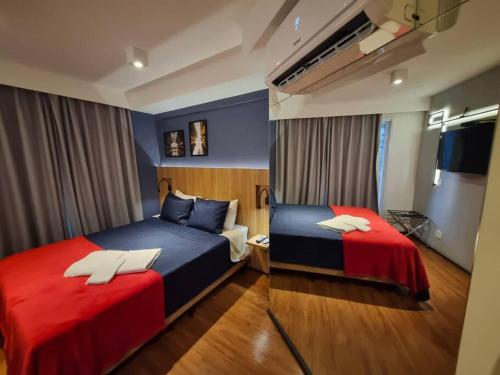 1 Schlafzimmer mit 2 Betten in Rot und Blau in der Unterkunft Lindo Studio Consolação, 312 in São Paulo