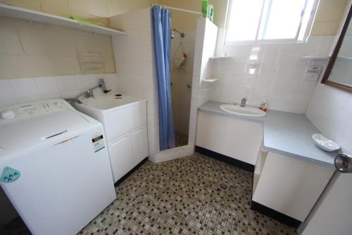 baño pequeño con lavabo y nevera blanca en Beach Unit 7 at Hat Head - No Sheets or Towels Provided en Hat Head