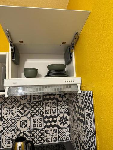 two pots and pans on a shelf in a kitchen at cosy moderne chaleureux équipé proche tram in Talence