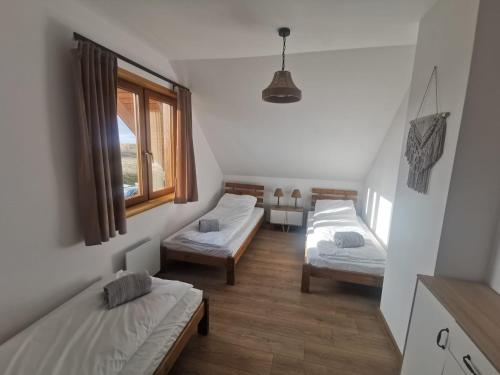 Zimmer mit 3 Betten und einem Fenster in der Unterkunft Mazurski Horyzont in Leleszki