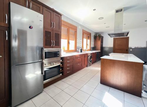 a kitchen with a stainless steel refrigerator and wooden cabinets at Casa Rural Alvaro in Albares