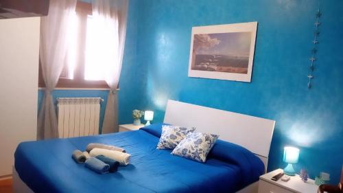 Un dormitorio azul con una cama con un osito de peluche. en Villa helios en Barletta