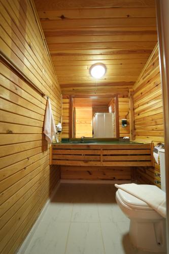 a wooden bathroom with a toilet and a refrigerator at Kasaba Butik Otel in Fethiye