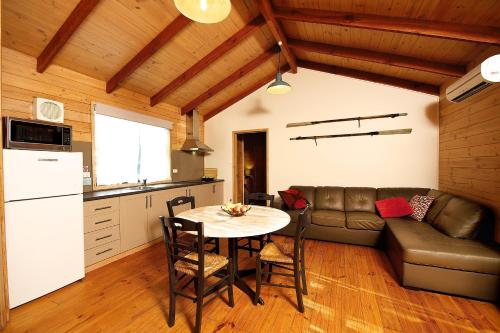 eine Küche und ein Wohnzimmer mit einem Tisch und einem Sofa in der Unterkunft Lakes and Craters Holiday Park in Camperdown
