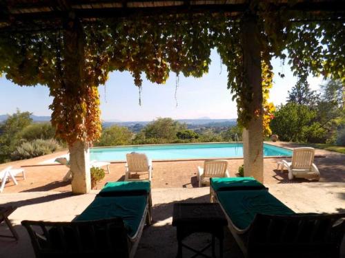 a view of a pool with chairs and a gazebo at SCAPPO IN UMBRIA, il Fienile in Fornole