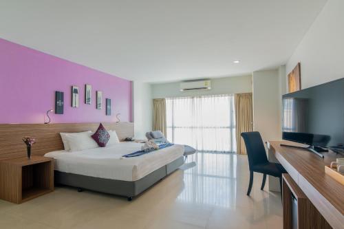 a bedroom with a bed and a desk and a television at The Lantern Resorts Patong - SHA Extra Plus in Patong Beach