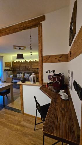 a living room with a wooden table and a kitchen at Appartamento "Roby" in pieno centro a Cavalese in Cavalese