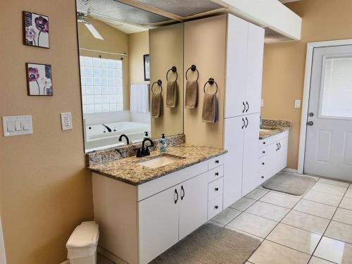 a bathroom with a sink and a large mirror at 4 Bedroom home with heated pool by the beach! in Clearwater Beach