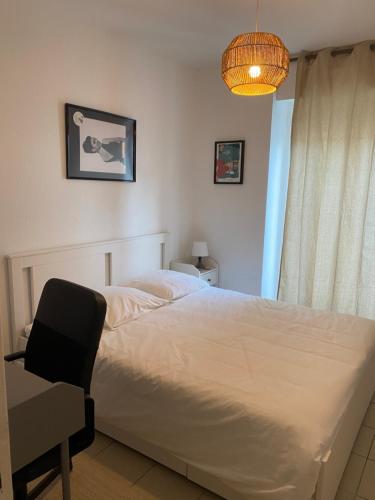 ein Schlafzimmer mit einem Bett, einem Stuhl und einer Lampe in der Unterkunft Cozy appartement en plein coeur de Dax Fontaine Chaude in Dax