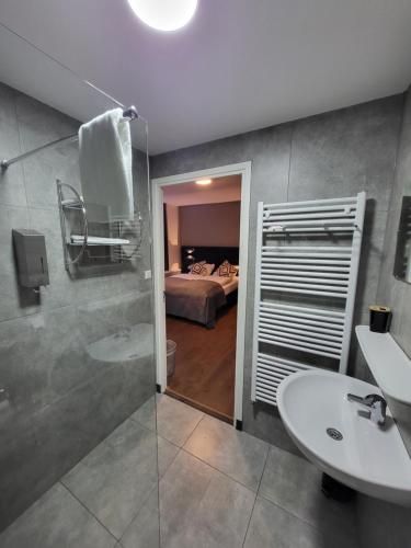 a bathroom with a sink and a toilet and a bed at Hotel Broer & Zus in The Hague