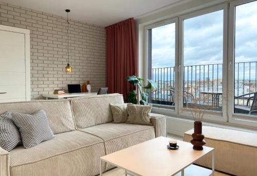 a living room with a couch and large windows at apartamenty-wroc Kurkowa 14 in Wrocław