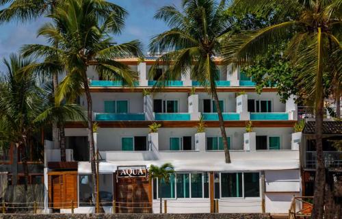 ein Hotel am Strand mit Palmen in der Unterkunft Aqua by Sambass in Morro de São Paulo