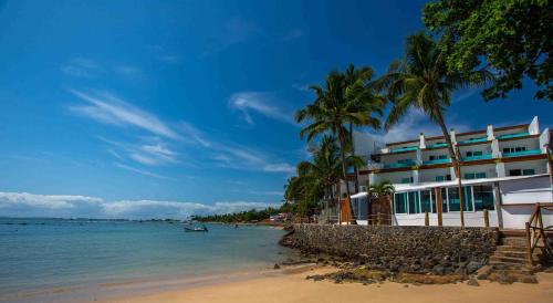 un hotel en la playa con palmeras y el océano en Aqua by Sambass, en Morro de São Paulo