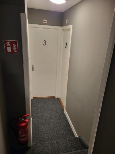 a hallway with a white door with numbers on it at Hotel Broer & Zus in The Hague