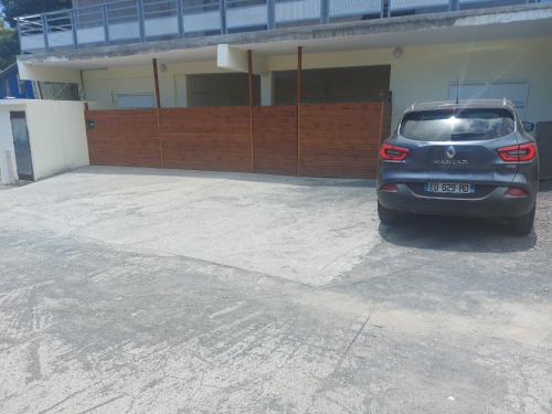 un coche aparcado en un aparcamiento frente a un edificio en Sublimes T2 à 2 min à pied de l'aéroport en Pamandzi