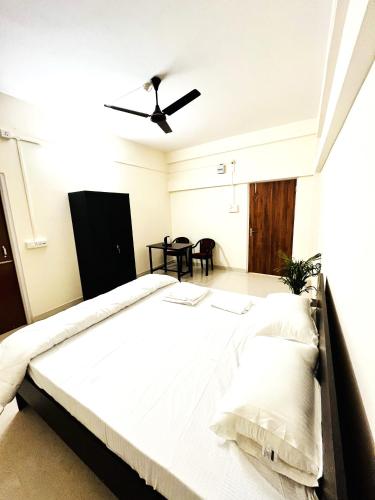 a bedroom with a large bed with a ceiling fan at Queen's Residency in Guwahati