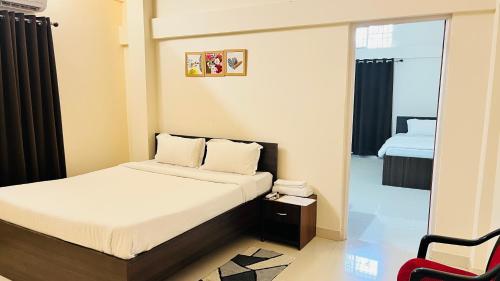 a small bedroom with a bed and a mirror at Queen's Residency in Guwahati