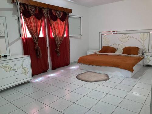 um quarto com uma cama com cortinas vermelhas e uma janela em L’escale petite terre em Labattoir