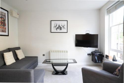 a living room with a couch and a table at Trendy & Central 2BD Flat -Brick Lane Shoreditch! in London
