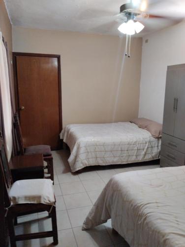 una habitación de hotel con 2 camas y una silla en habitaciones confortables 