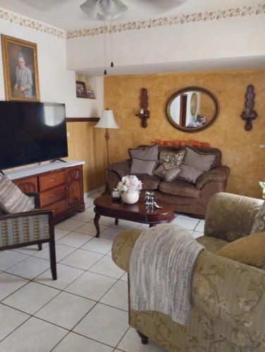 ein Wohnzimmer mit einem Sofa und einem Flachbild-TV in der Unterkunft habitaciones confortables 