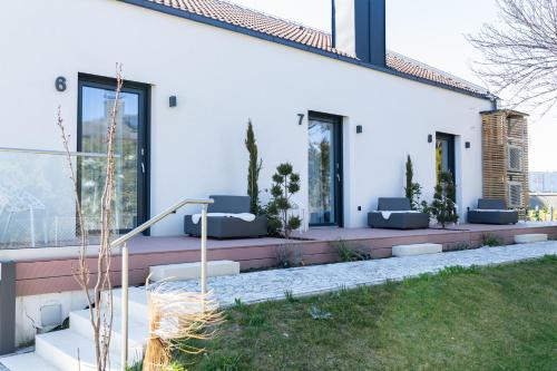 a white house with a patio with couches and windows at mariaAPPARTMENTS in Gramatneusiedl